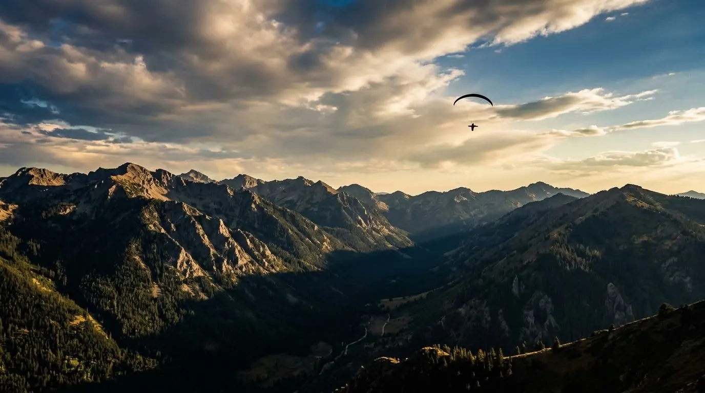 Parapendio sopra una valle alpina al tramonto